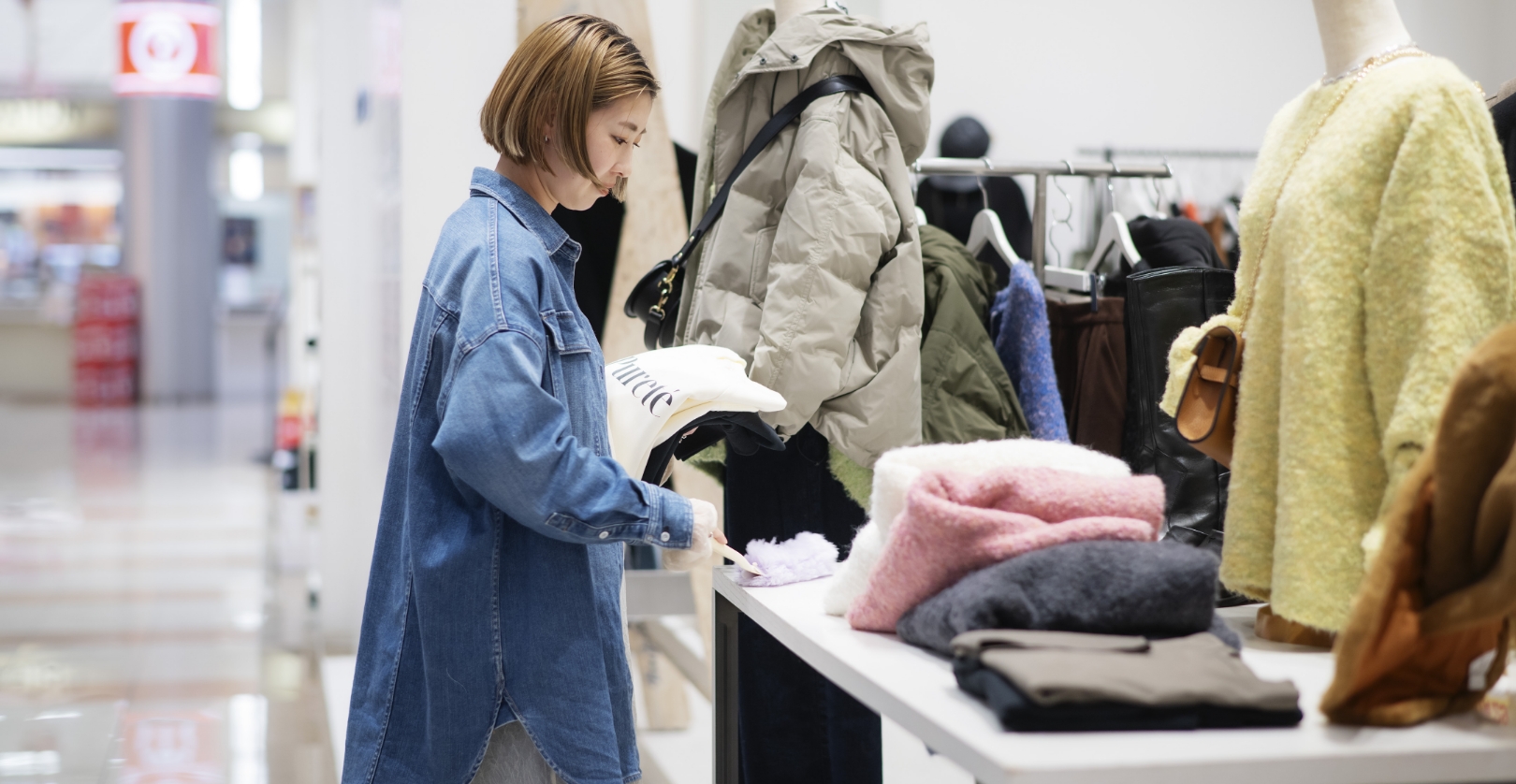 店頭の服をそろえる女性